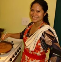Noy Thrupkaew cooking and smiling